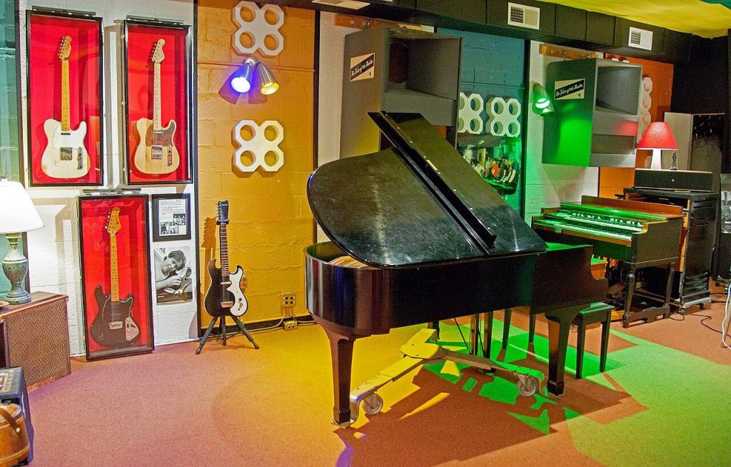 Sala di ripresa dei Muscle Shoals Sound Studios con pianoforte a coda, organo Hammond e chitarre esposte alle pareti