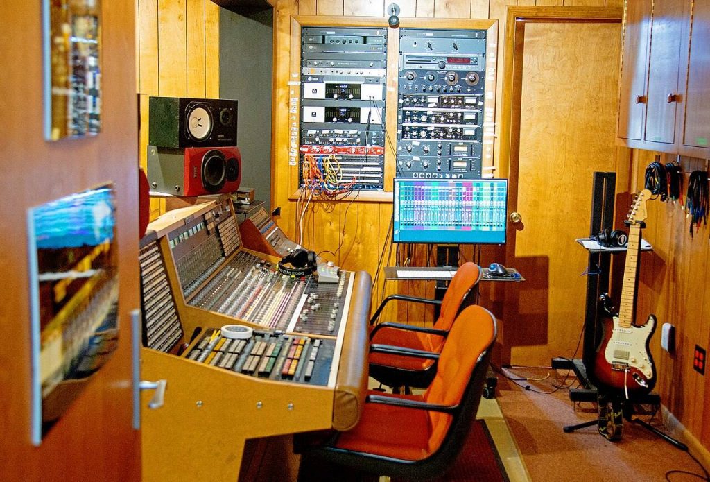 Regia dei Muscle Shoals Sound Studios con banco di missaggio, rack di apparecchiature e pareti rivestite in legno