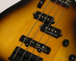 Primo piano del corpo di un basso elettrico sunburst con pickup split-coil e pickup a bobina singola sul ponte