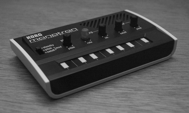 Korg monotron tenuto in mano, con il nastro sensibile al tocco che sostituisce la tastiera e le cinque manopole di controllo