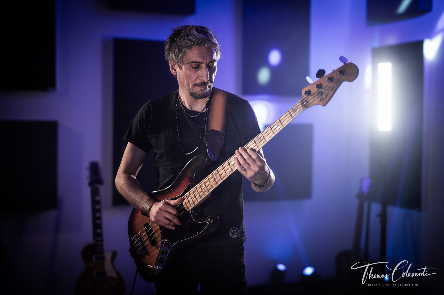 Campo medio, Marco Galiero suona il basso sunburst Fender in piedi nello studio