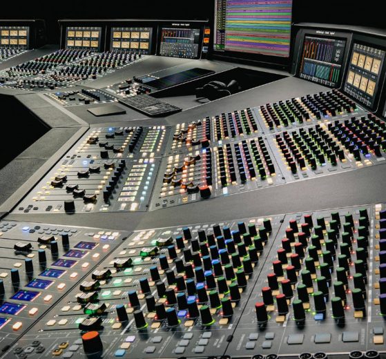 Console analogica SSL Odyssey da 48 canali vista di tre quarti, con le strisce di canale e la sezione centrale illuminate