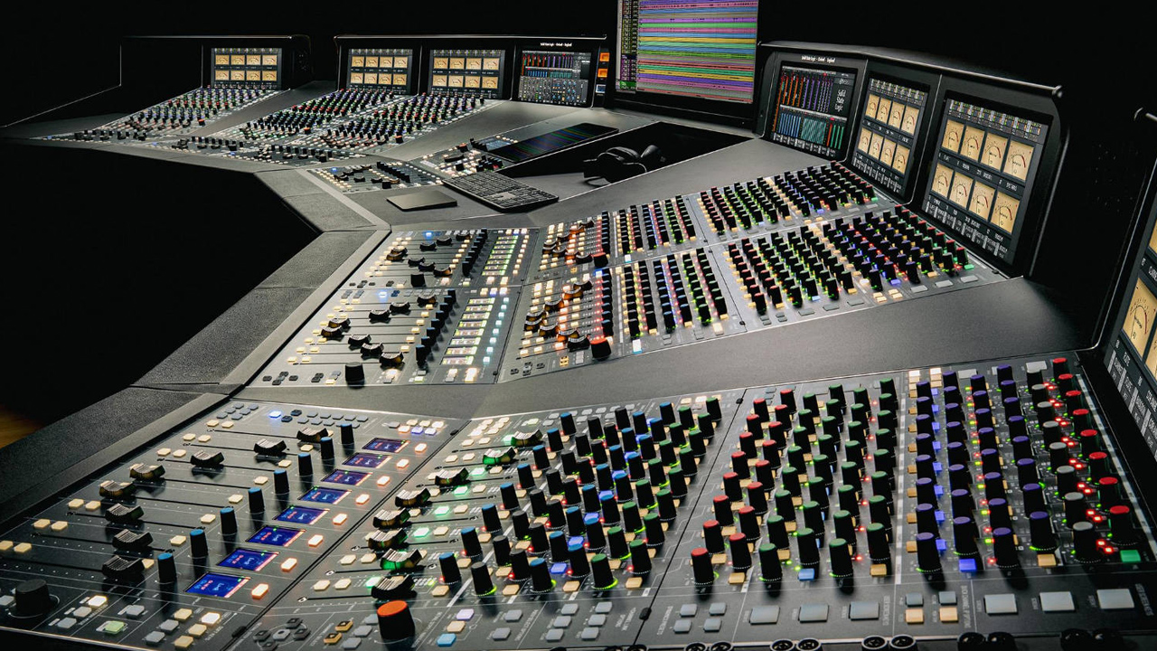 Console analogica SSL Odyssey da 48 canali vista di tre quarti, con le strisce di canale e la sezione centrale illuminate