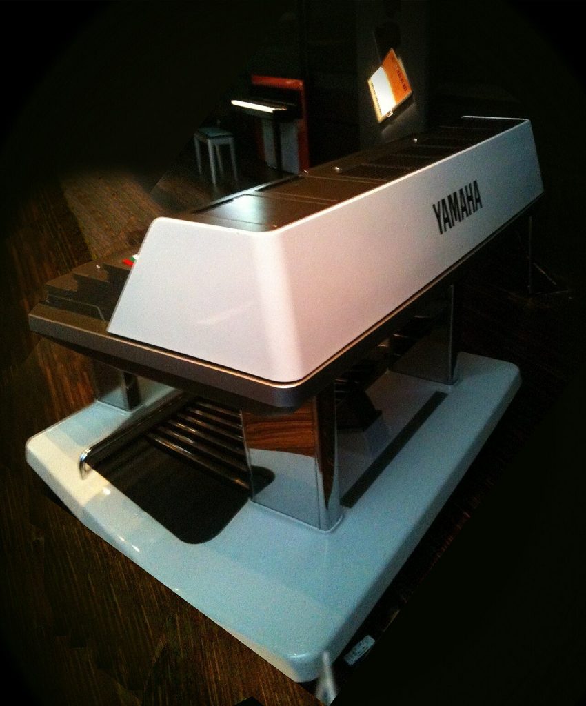 Vista posteriore del Yamaha GX1 al Yamaha Design Masterworks, che mostra il mobile di sostegno delle tre tastiere e la connettoristica di uscita